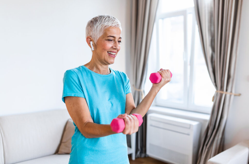 A smiling senior woman exercising with dumbbells.